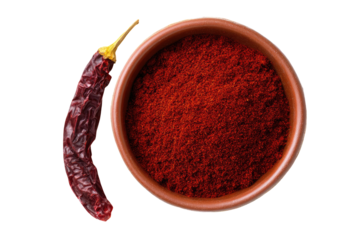 Dried chili pepper beside bowl of red spice powder