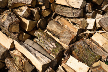 Chopped firewood stacked near the house. Heating season autumn-winter, heating, firewood for the winter.
