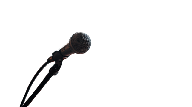 Close-up of a dark microphone. The microphone's metallic body and grille are visible. It's positioned against a completely black background