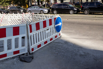 Striped road fence. Road sign of detour. Road works. Vehicles on the road