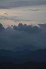 明け方に山にかかる雨雲と朝焼け