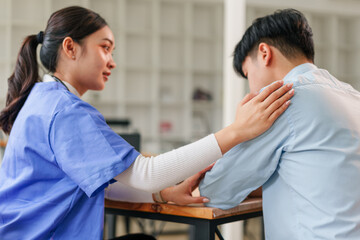 Young nurse comforting stressed patient with reassuring touch and calm expression in clinic counseling setting