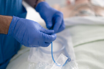 Doctor wearing blue surgical gloves preparing medical catheter tube