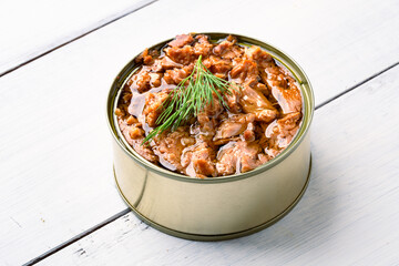 Canned tuna in brine isolated on white wooden background