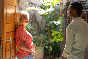 In sunny garden, friends talking and smiling, enjoying each other's company