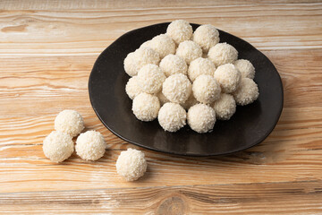 Coconut candies pile, coco ball. White truffle ball, indian ladoo or laddu with sweet cream and coco