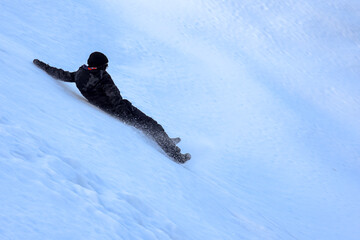 Hiker sliding down a snowy slope after losing balance on a winter hike
