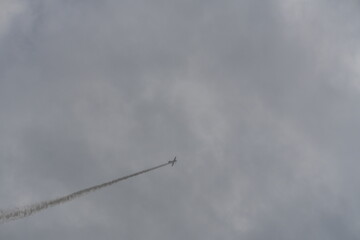 Plane and Its Smoke Trail Against a Dramatic Sky