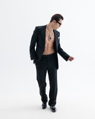 sexy businessman in suit with no shit showing muscles while looking to side