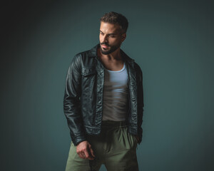 handsome fashion guy in black leather jacket looking to side
