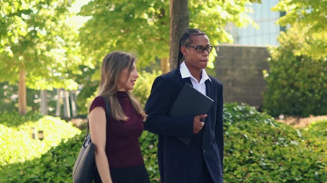 multicultural Business partners walking and talking in the financial district - Powered by Adobe