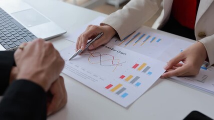 Skilled business professionals collaborating at conference table, analyzing financial performance charts and discussing strategic market insights during team meeting - Powered by Adobe