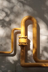 yellow gas pipe on the brick wall of the house