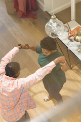 Dancing joyfully, friends having fun together in cozy home environment