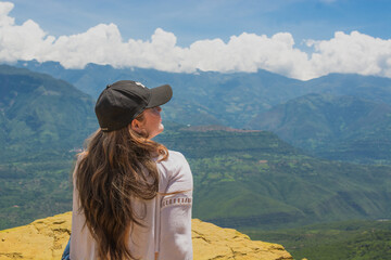 Latina teenager admiring scenic mountains at El Salto del Mico viewpoint in Barichara Colombia
