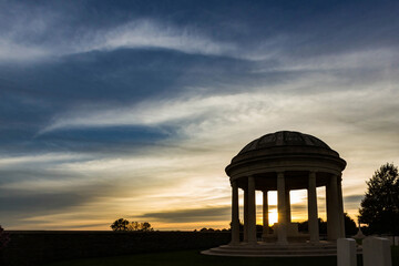 Obraz premium Autumn mood with sunset and wispy clouds over british military burial place. Bedford House Cemetery, remembrance site of World War One near Ypres, Belgium.