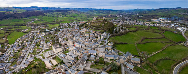 Aerial panoramic view around the old town and city Sévérac-d'Aveyron in France on a sunny afternoon