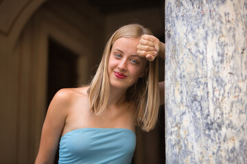 Portrait of a young woman, blonde, blue eyes, slim, wearing a light blue dress, innocent and...