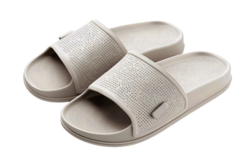 Pair of modern spa slide sandals in muted gray tone, soft matte texture, perforated wide band and overlapped layout, isolated on transparent background.
