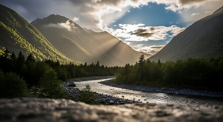 Sunlight filtering through clouds over a winding river in a lush mountain valley.