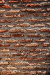 Exposed brick wall showcasing rustic texture in an urban outdoor setting with sunlight highlighting the details