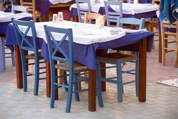 a blue table and chairs set up in a small avernus on the shore in the evening light
