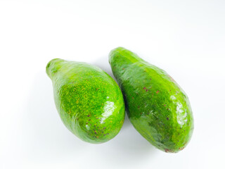 fresh green avocados placed on a white background, showing their shiny skin and natural texture