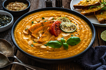 Pumpkin cream soup on wooden table	