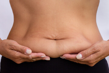 Close-up of womans abdomen, palms resting on lower belly