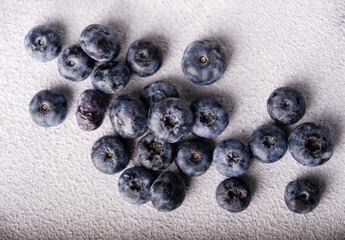 Blueberries scattered on a light background, top view