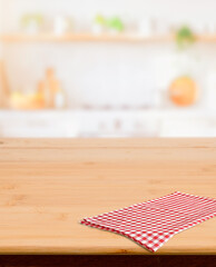 Wooden surface with checkered cloth and blurred home kitchen interior