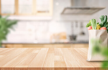 Fresh groceries in paper bag on wooden countertop with kitchen background
