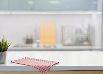 Modern kitchen counter with red checkered cloth and blurred background