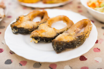 three pieces of fried carp on a white plate