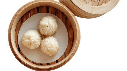 Three light-colored steamed dumplings rest on a white paper liner inside a wooden bamboo steamer basket
