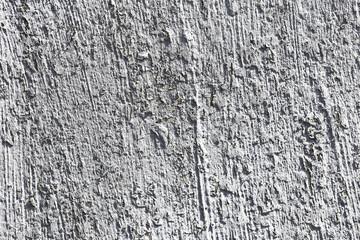 Rough gray concrete wall surface texture. Closeup of weathered cement background. Industrial construction material detail with cracks and scratches.