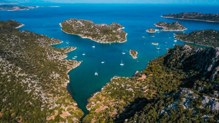 Beautiful aerial photograph of Gökkaya Bay in Kekova, Antalya, Turkey, known for its turquoise waters, hidden caves, and popular yacht anchorage.