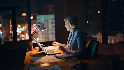 Businesswoman working late evening in office. Hardworking manager typing laptop