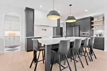Kitchen with a white counter and black chairs