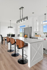 Kitchen with a white counter and wooden chairs