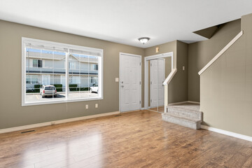 Large open living room with a window and a staircase