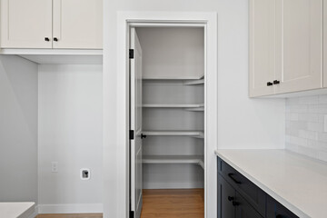 White and black kitchen with a pantry and a sink