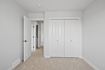 White bedroom with a white closet and a white door