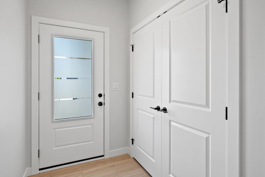 White door with a frosted glass window and a black handle