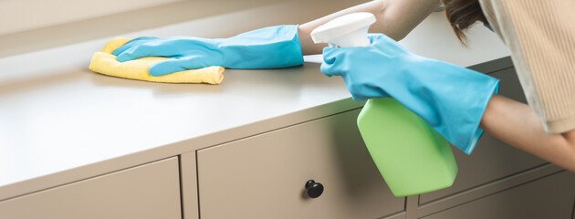 Cleanliness, asian young woman work chore cleaning on cupboard at home, hand wearing glove using wiping cloth remove dust with spray bottle. Household hygiene clean up, equipment tool for cleaning