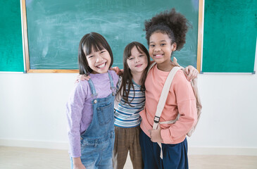 Portrait of young happy little asian toddler student girls with backpack isolated on yellow background. Education for primary school, childhood education knowledge, lifestyle back to school concept