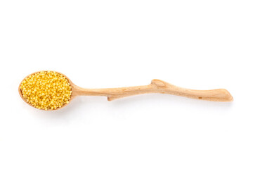 Millet, ancient African grain, in a spoon on a white background, overhead flat lay shot. Healthy vegan side dish