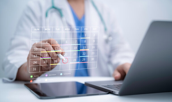 Doctor scheduling appointment on digital calendar using laptop and tablet, healthcare planning, telemedicine booking and innovation concept for online medical consultation and patient management