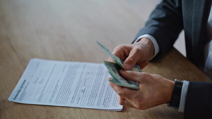 Boss hands counting salary at wooden desk closeup. Unknown man holding money