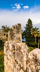 Obraz premium Ancient stone wall and towers against a partly cloudy sky